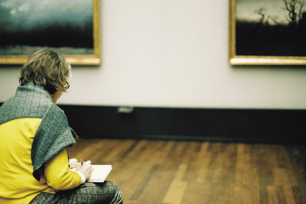 Femme qui dessine dans un musée