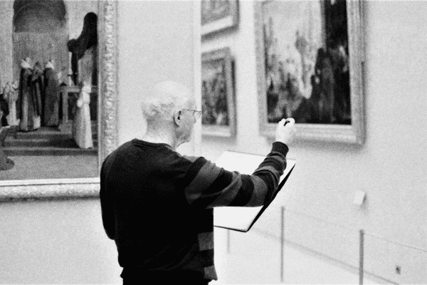 Homme qui réalise un croquis dans un musée
