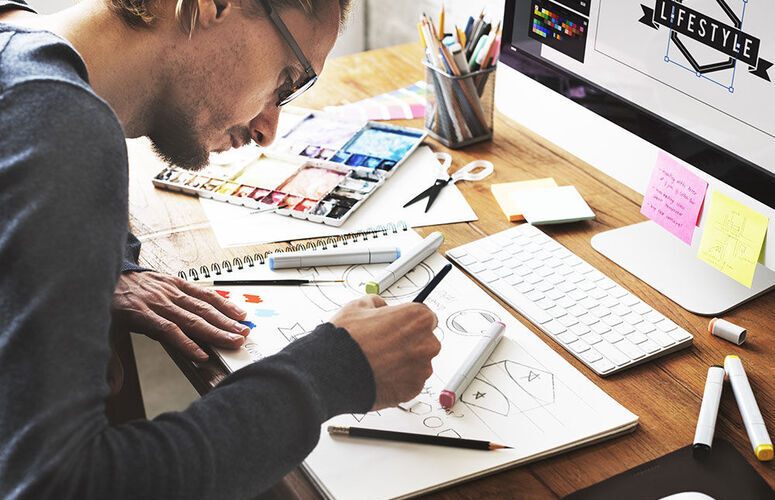 Illustrateur qui dessine sur un carnet