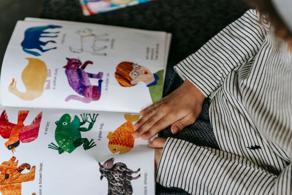 enfant qui lit un livre avec des illustration